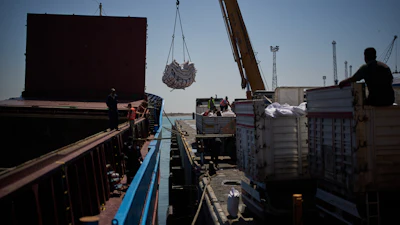 Workers offload cargo of rice from a feeder vessel into trucks at Umm Qasr Port, Iraq, March 27, 2026.