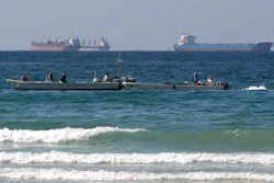 Fishermen work in front of oil tankers south of the Strait of Hormuz Jan. 19, 2012, offshore the town of Ras Al Khaimah in United Arab Emirates.