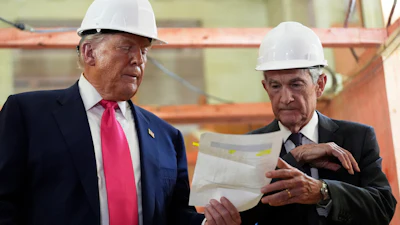 Federal Reserve Chairman Jerome Powell, right, and President Donald Trump look over a document during a visit to the Federal Reserve, July 24, 2025, Washington.