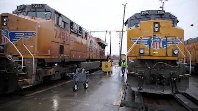 A Union Pacific worker walks between two locomotives in a railyard in Council Bluffs, Iowa, Dec. 15, 2023.