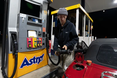 Luciano V. replaces the fuel nozzel after filling the tank of their 1999 Mazda Miata at an Astro gas station on Wednesday, April 29, 2026, in Portland, Ore.
