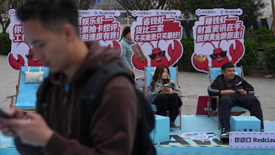 Shoppers rest at a RedClaw AI promotion booth outside a shopping mall in Beijing, March 28, 2026.