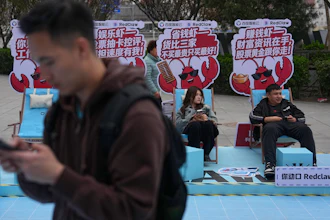 Shoppers rest at a RedClaw AI promotion booth outside a shopping mall in Beijing, March 28, 2026.