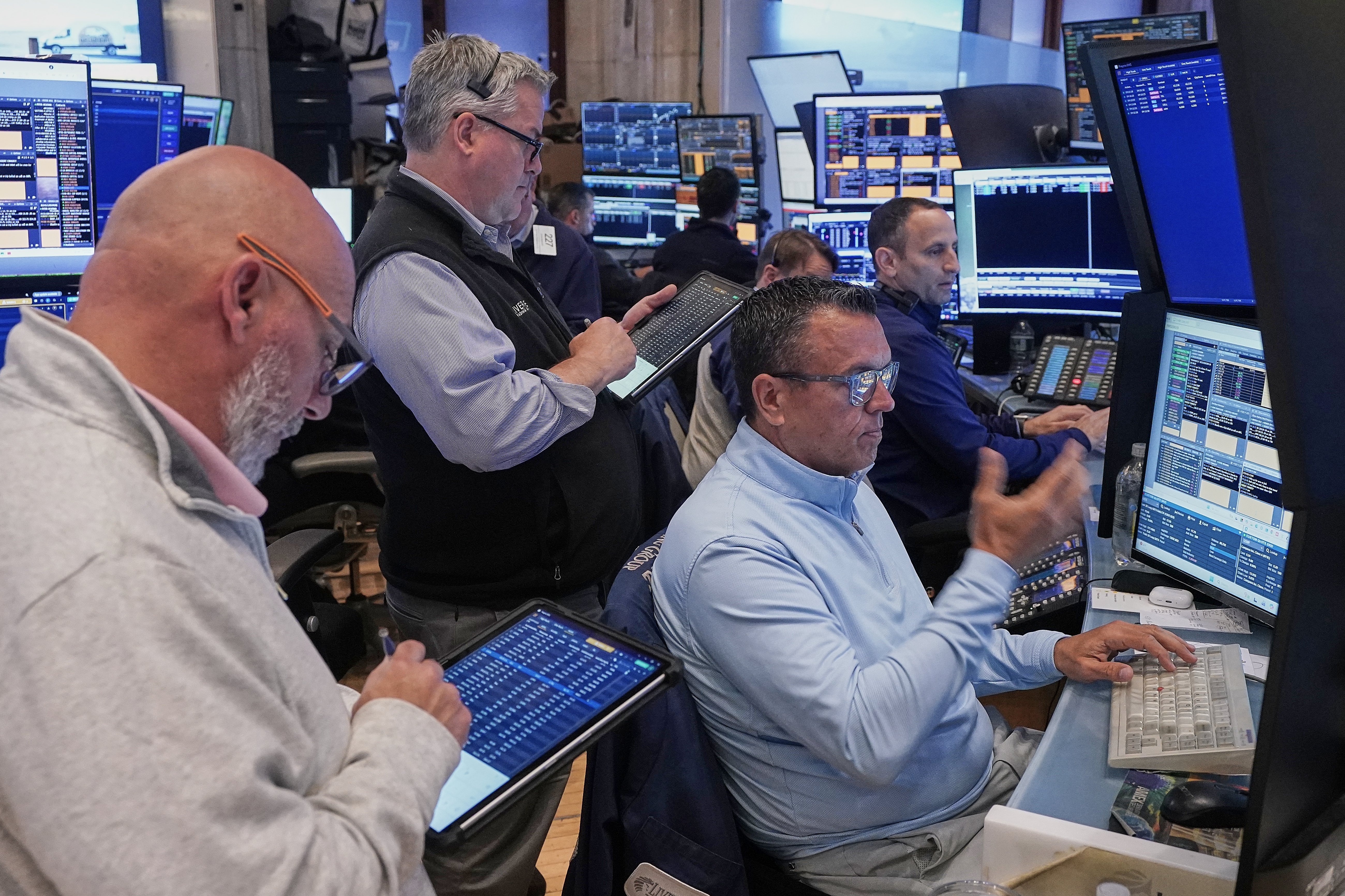 Robert Finnerty Jr., foreground right, works with colleagues on the floor of the New York Stock Exchange, May 7, 2026.