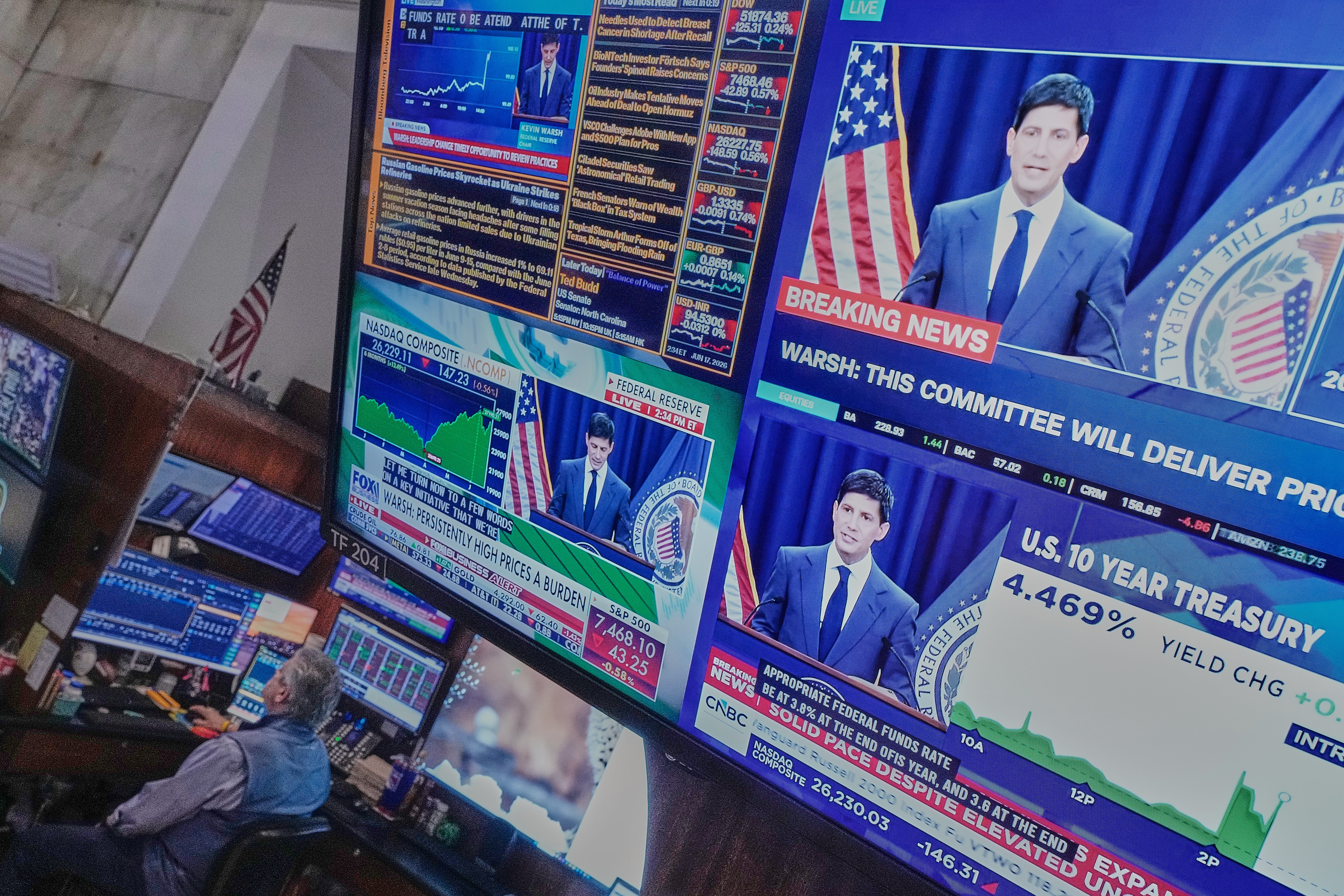 Federal Reserve Chair Kevin Warsh's press conference appears on screens on the floor of the New York Stock Exchange, June 17, 2026.