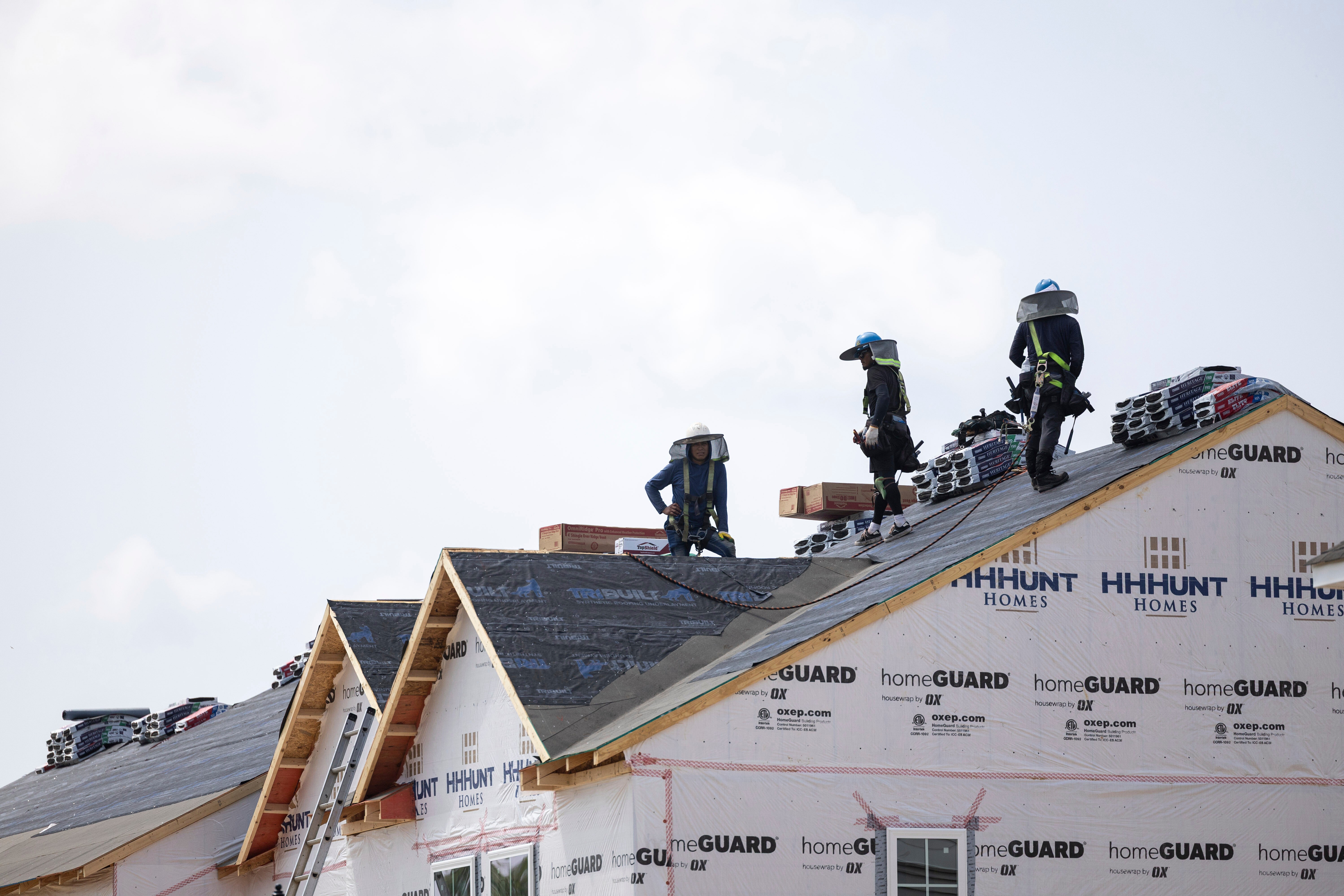 People work on the roof of a new housing development in Sandston, Va., June 6, 2025.