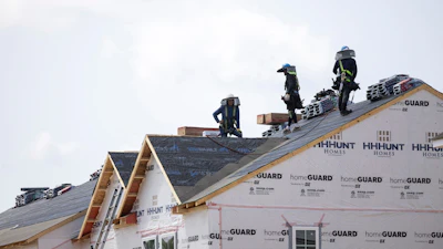 People work on the roof of a new housing development in Sandston, Va., June 6, 2025.