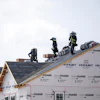People work on the roof of a new housing development in Sandston, Va., June 6, 2025.