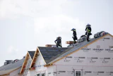 People work on the roof of a new housing development in Sandston, Va., June 6, 2025.