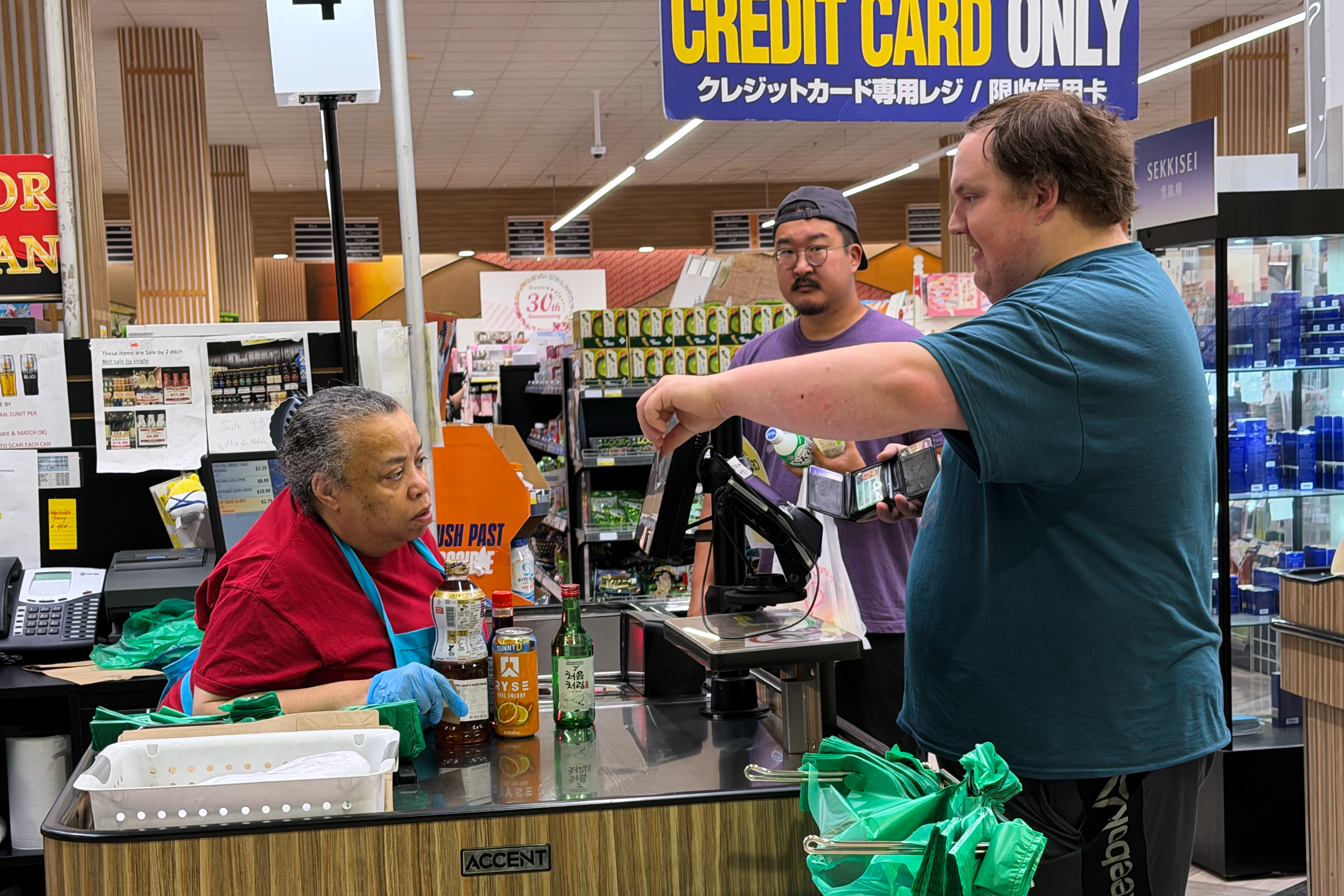 An employee checks a customer's identification card before checking out alcohol at a grocery store in Arlington Heights, Ill., July 6, 2026.