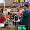 An employee checks a customer's identification card before checking out alcohol at a grocery store in Arlington Heights, Ill., July 6, 2026.