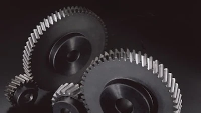 Metallic gears and cogwheels arranged on dark background, representing mechanical engineering and industrial machinery