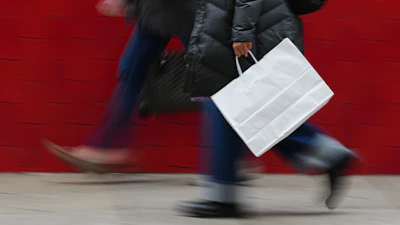 A person carries a shopping bag in Philadelphia, Dec. 10, 2025.