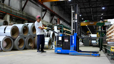 A worker operates a forklift in front of steel coils at Ideal Roofing in Ottawa, Aug. 25, 2026.