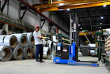 A worker operates a forklift in front of steel coils at Ideal Roofing in Ottawa, Aug. 25, 2026.