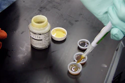 Laboratory technician examining liquid samples in small vials during scientific testing procedure