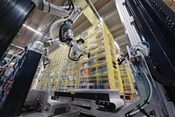 Robotic automation system with mechanical arms operating above yellow storage racks in an industrial warehouse facility