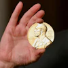A Nobel medal is held up during a ceremony in New York, Dec. 8, 2020.