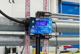 EFC blue control device mounted on industrial factory equipment with colorful overhead cables and structural beams