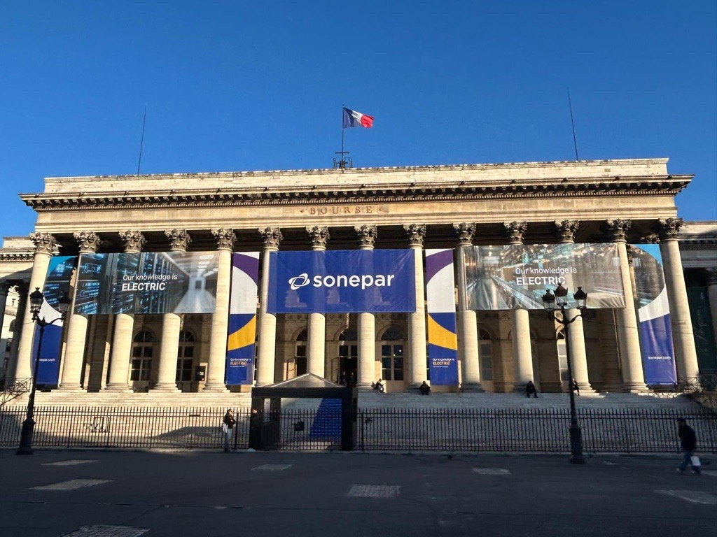 Classical building facade with Sonepar blue banner signage and columns under clear blue sky