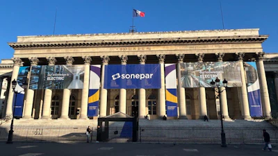 Classical building facade with Sonepar blue banner signage and columns under clear blue sky