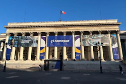 Classical building facade with Sonepar blue banner signage and columns under clear blue sky