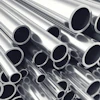 Stacked polished metal tubes and pipes arranged diagonally showing circular openings and reflective surfaces